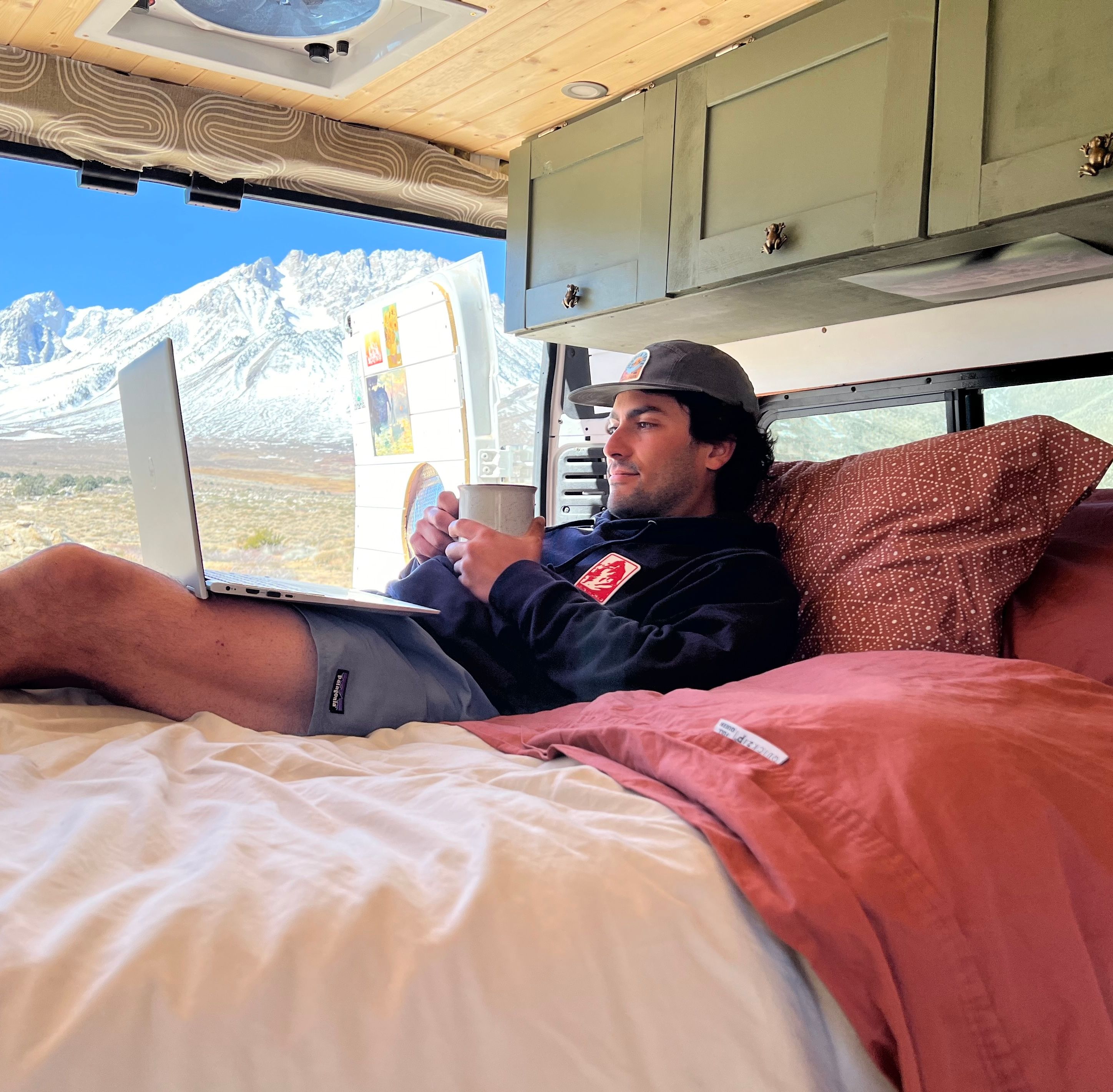 Van bed with QuickZip sheets and mountain background