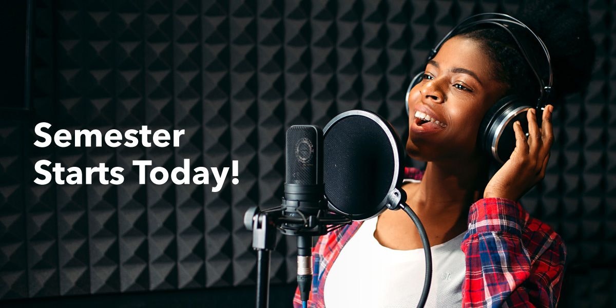 Person singing into a microphone in a recording studio