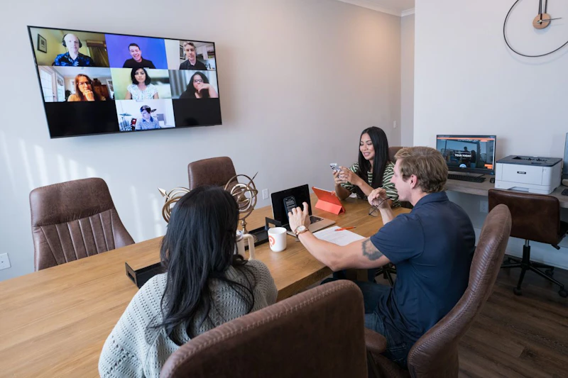 A woman on a video call at a desk set up in a bedroom