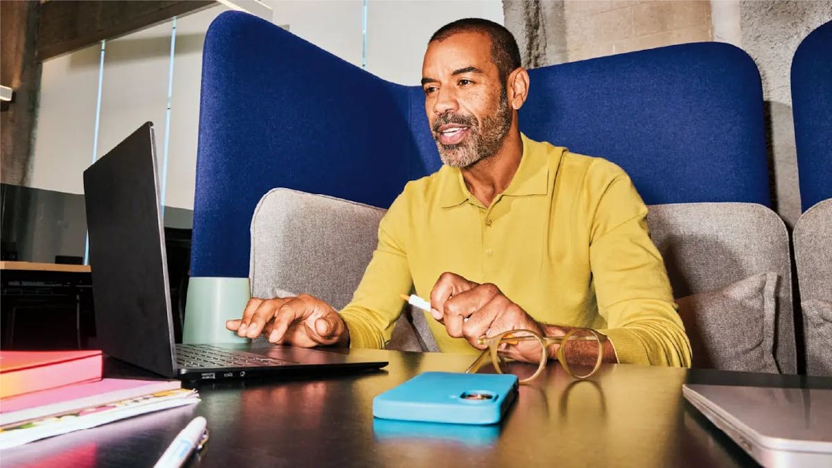 An HR manager at his desk follows a global employee offboarding guide on his laptop to ensure a smooth and compliant exit process.