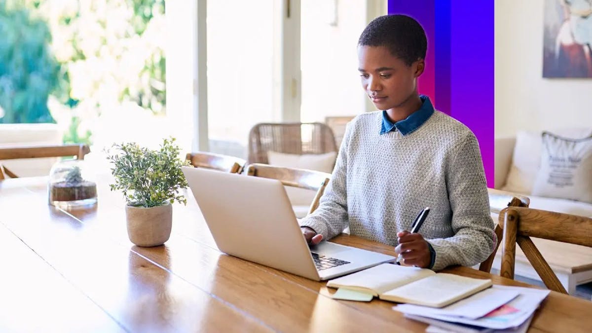 Woman working from home at dining table