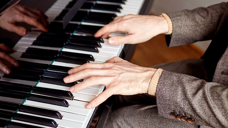 Two hands playing a piano.
