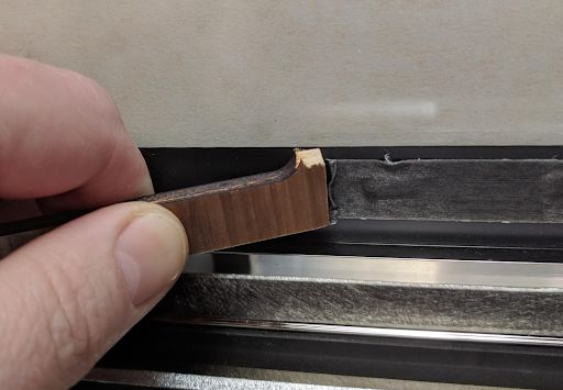 Left over adhesive being scraped off of the Glowforge lid interior