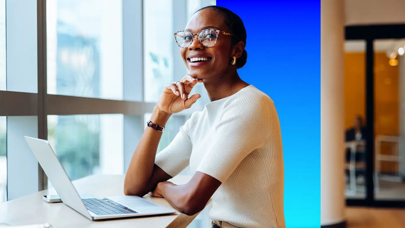 woman working on computer at desk next to window
