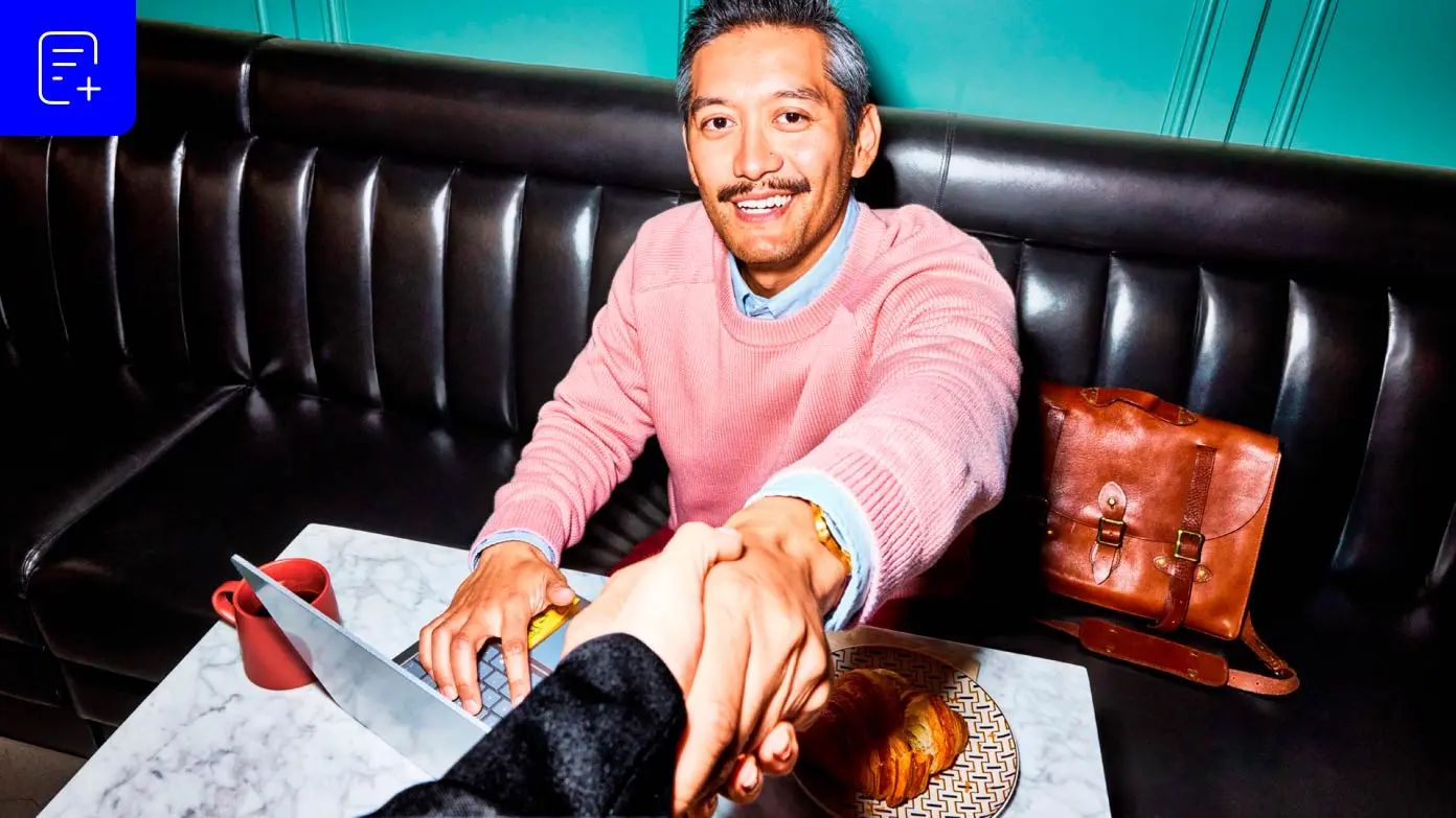 Alt text not provideda man sitting on a black leather bench in what appears to be a cafe