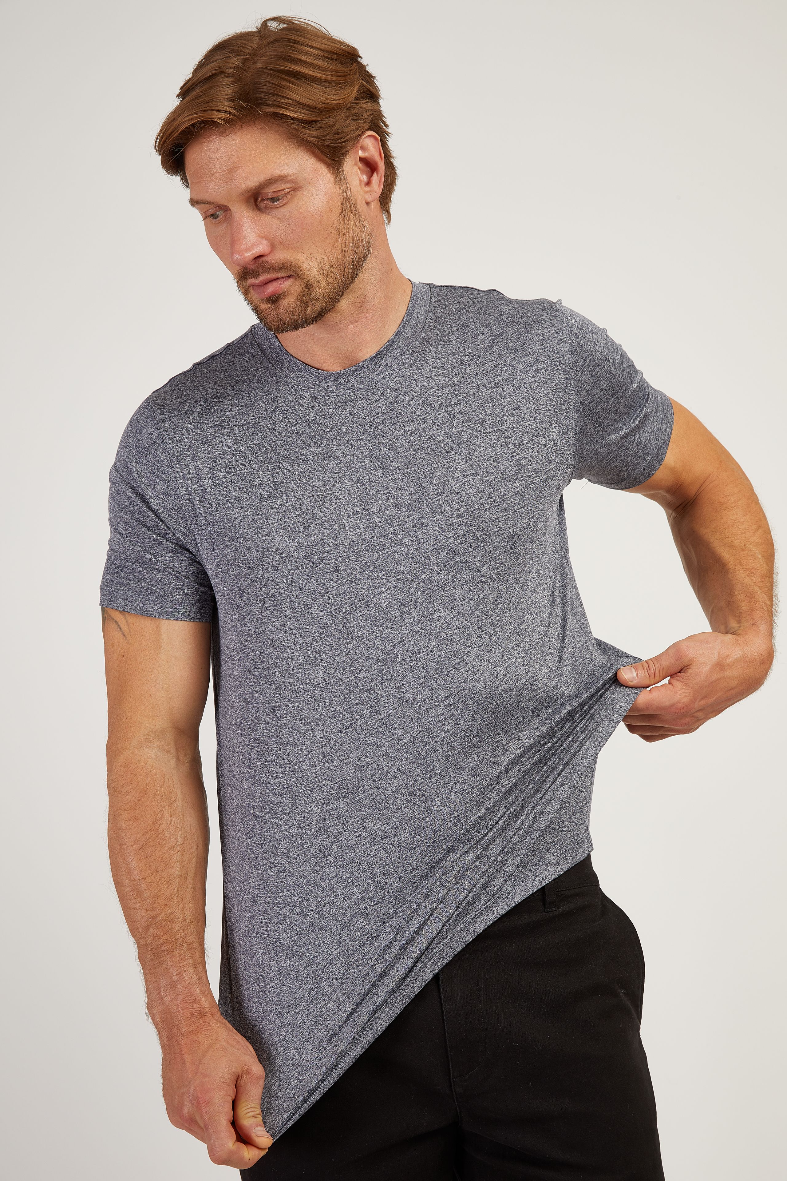 Man stretching the hem of a Tech Tee