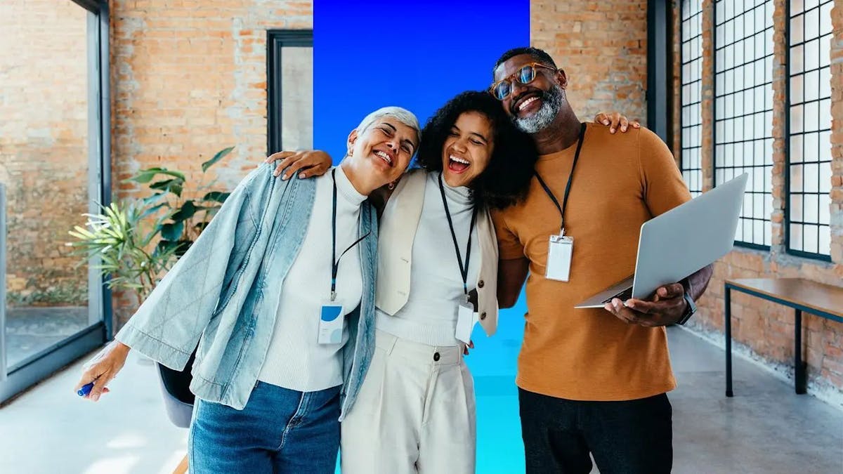 three business people wrapping arms around each other's shoulders