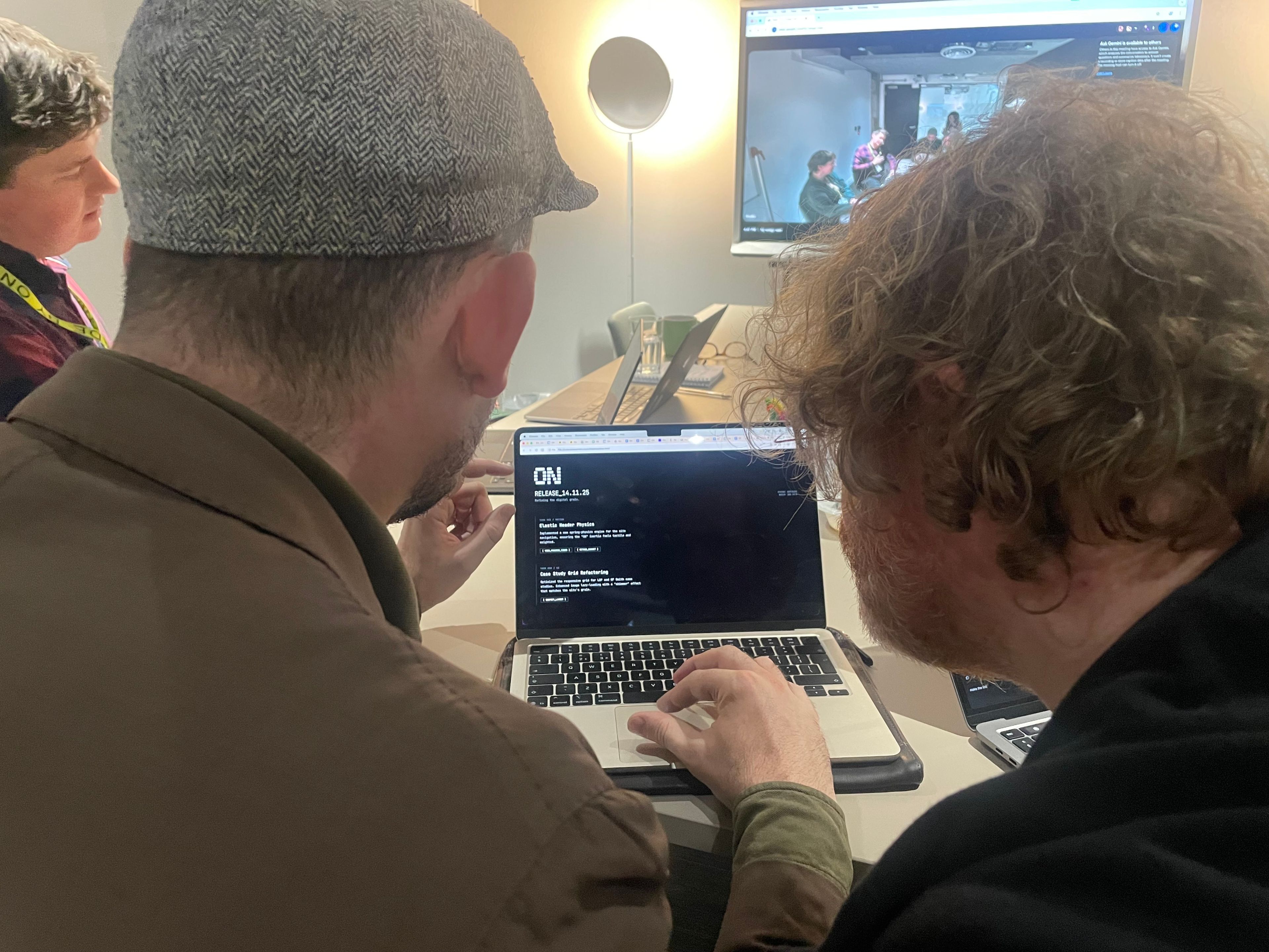 The team gathered around the table looking at a laptop