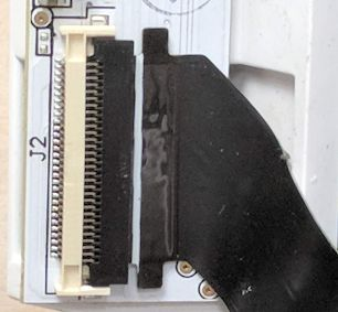 A cable fully inserted. A white line on the cable is parallel to the socket it's inserted into.