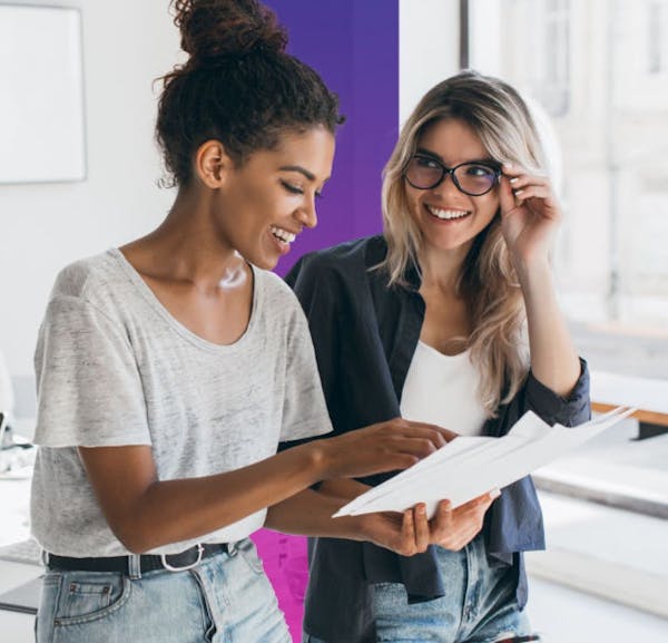 Two Office Managers Looking Over Documents