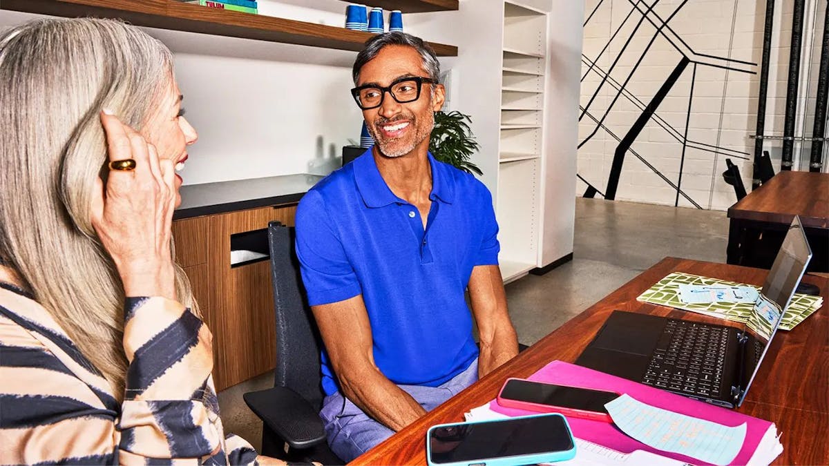 two individuals engaged in a conversation in an office setting