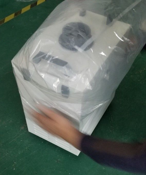 Two hands being used to remove plastic bag from filter unit
