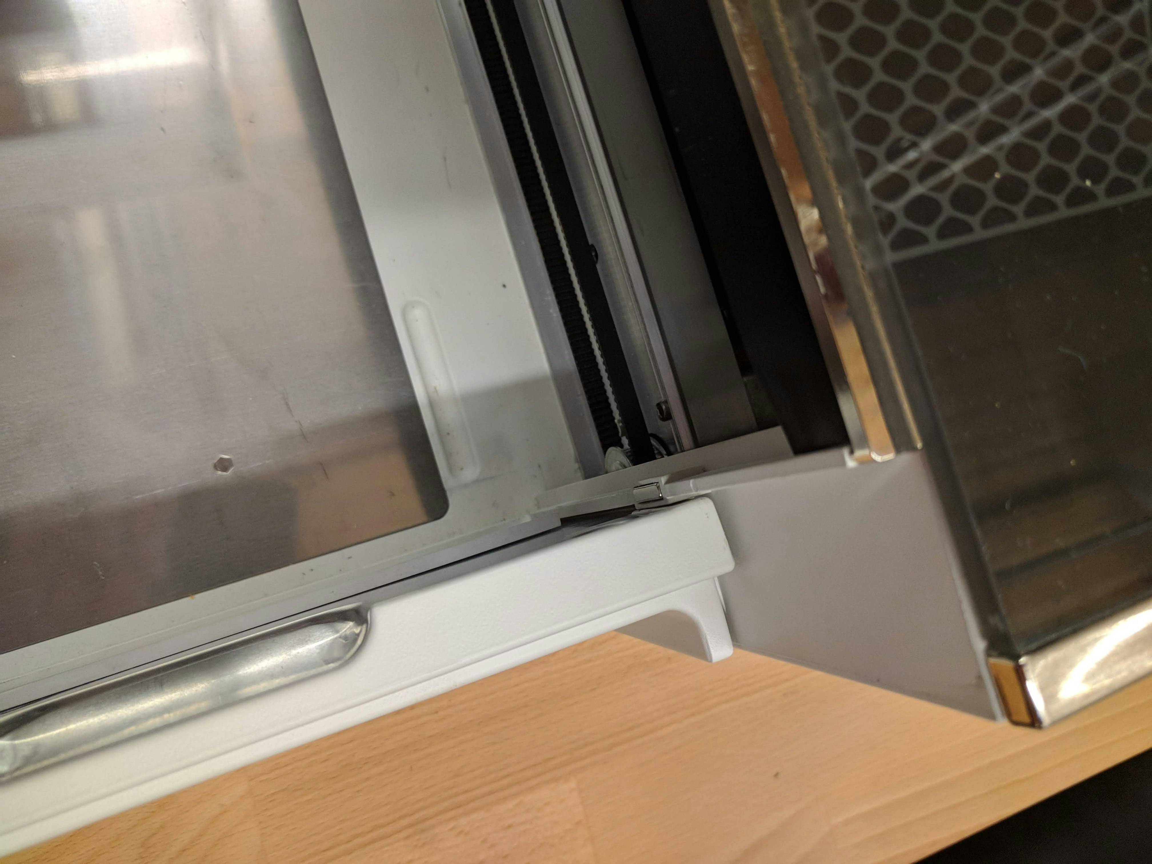 The right side of the closed front door of the Glowforge with the lid open. The door closes completely and there is no damage.