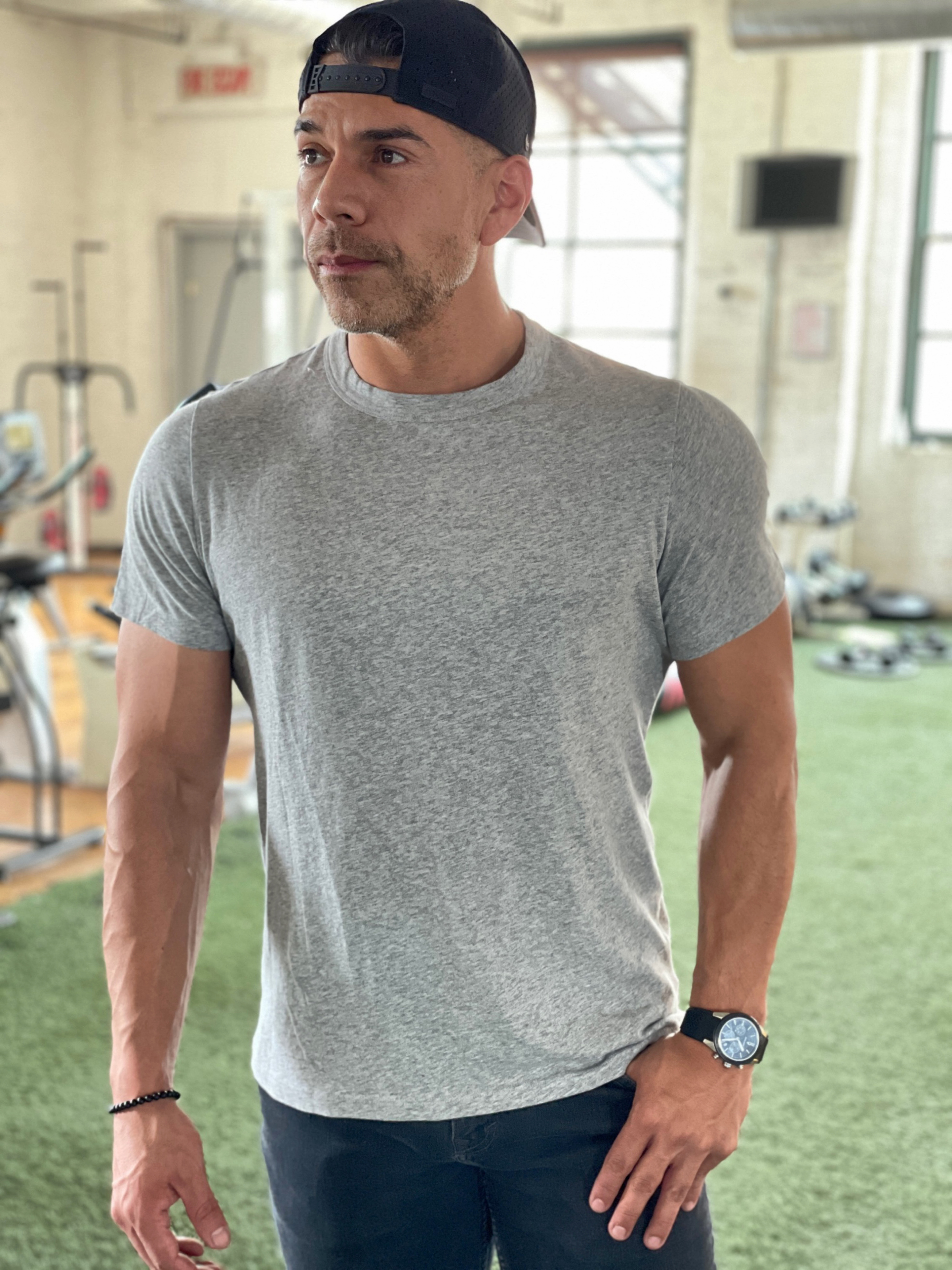Man wearing a heather gray Tech Tee at the gym
