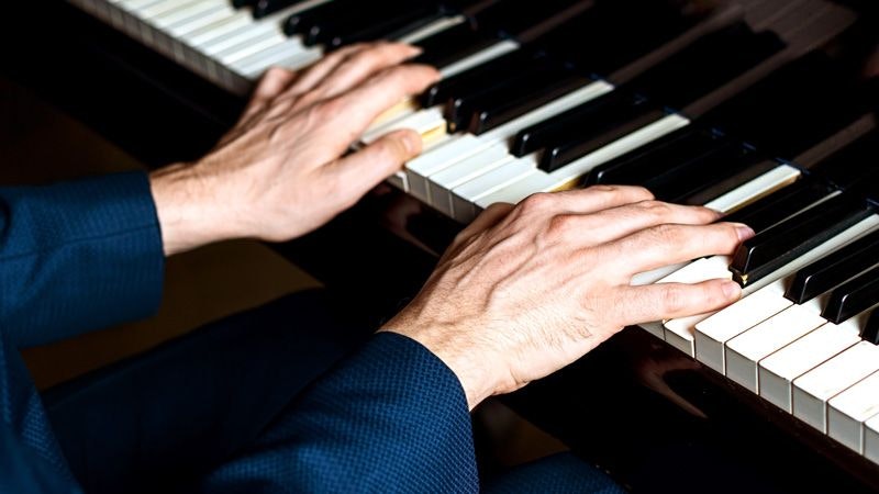 Two hands playing a piano.