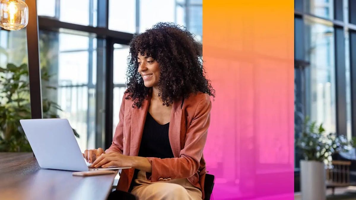 woman sitting at a table and working on her laptop