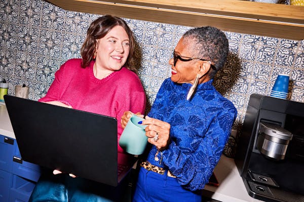 2 women working at a laptop on salary benchmarking