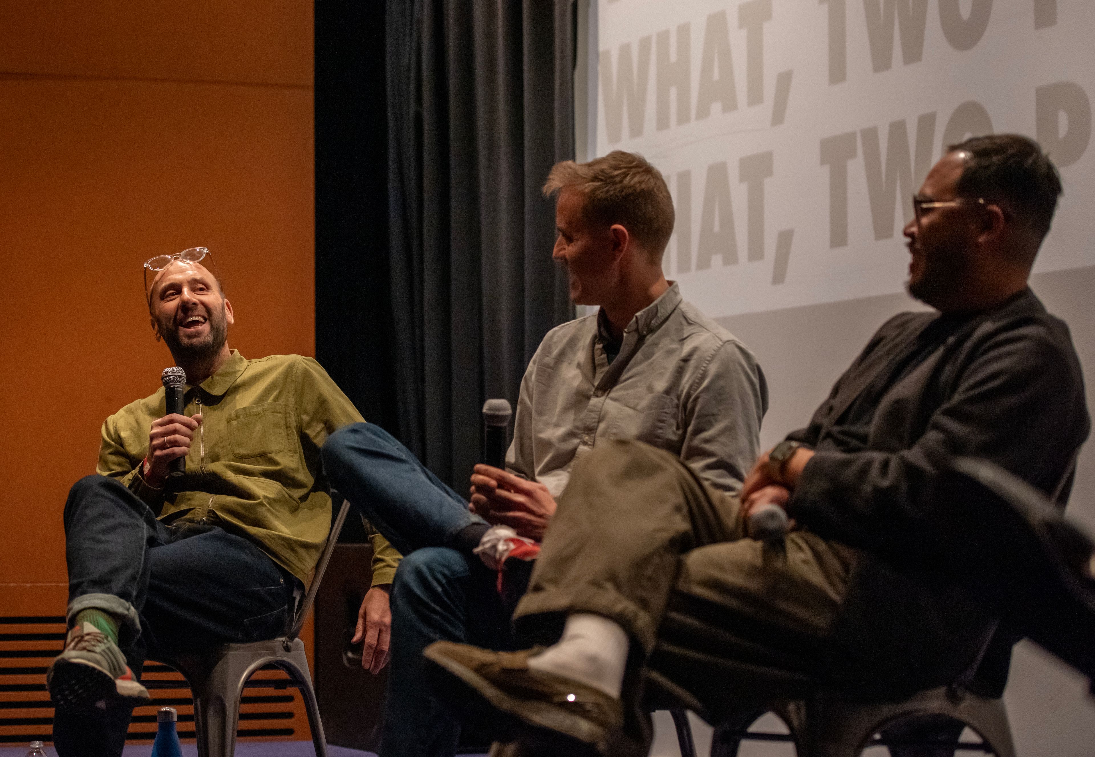 Three of the team with microphones in a roundtable discussion