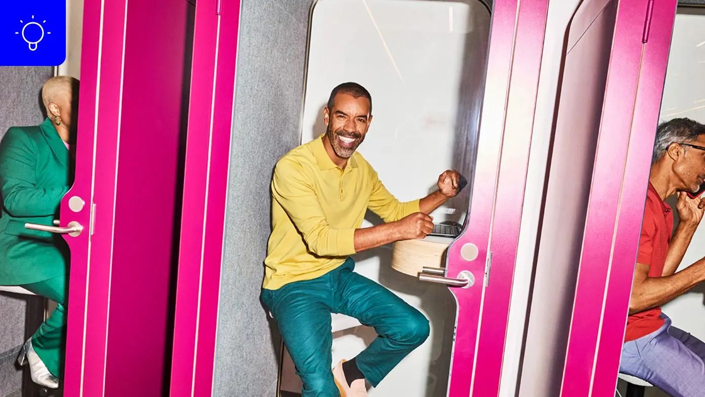  three individuals seated in a pink, enclosed booth