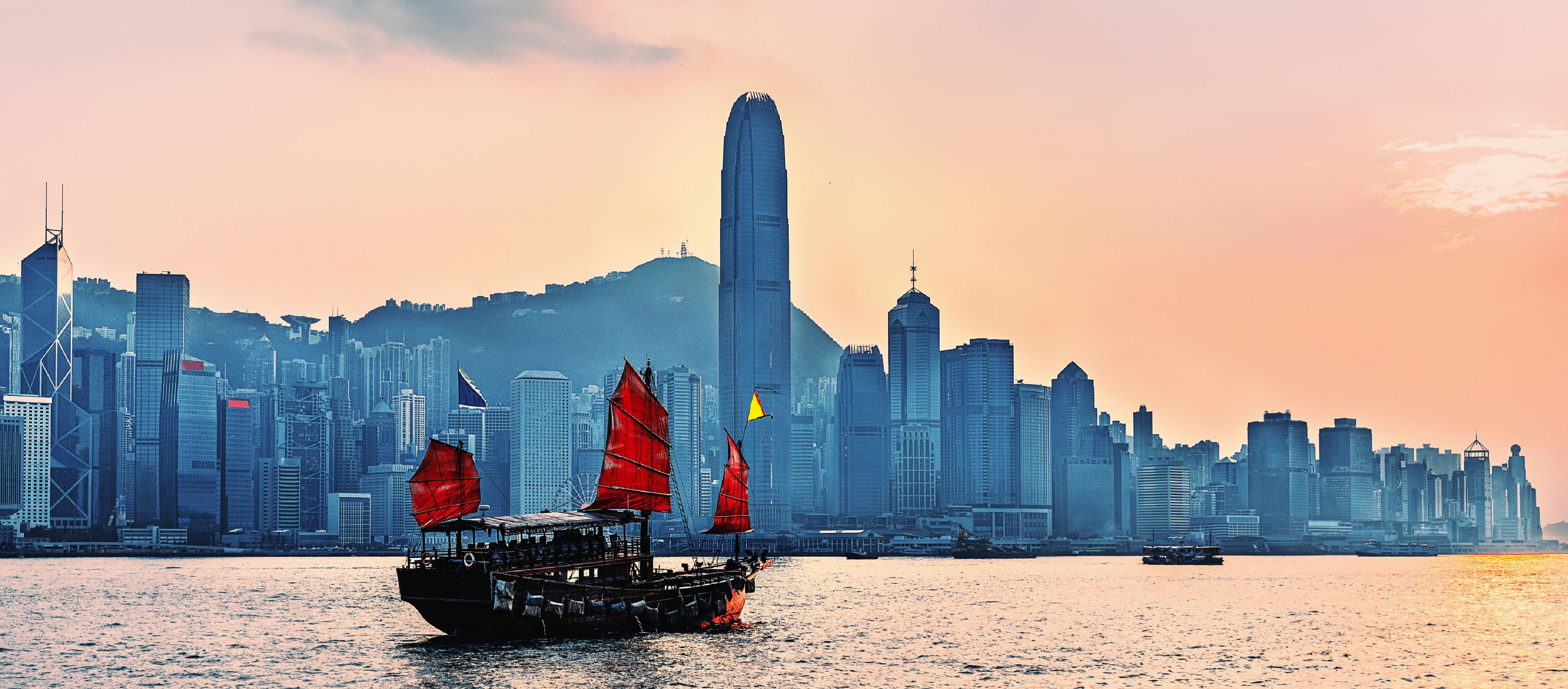 Hong Kong's  urban skyline with numerous high-rise buildings, including a prominent tall skyscraper in the center