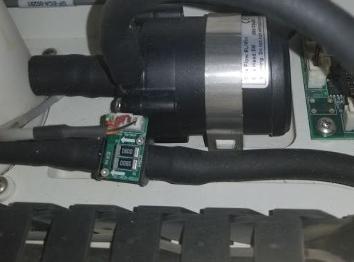 Small, green circuit board on a black tube in the left side of the Glowforge