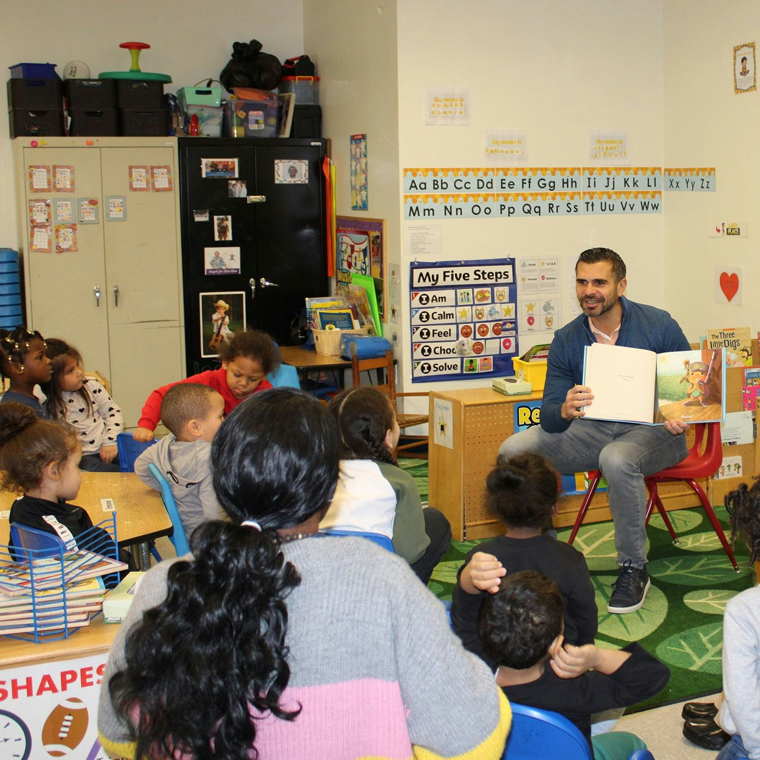 Volunteer reading in a classroom.