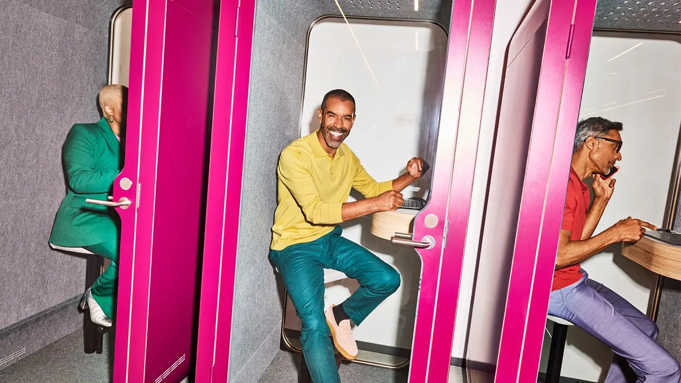 This image shows three individuals in a room with pink walls and doors.