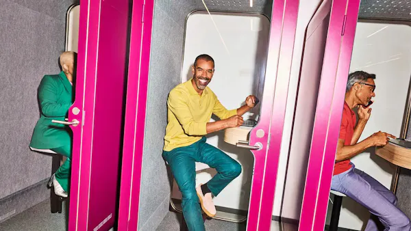 Bilden visar tre personer i ett rum med rosa väggar och dörrar.