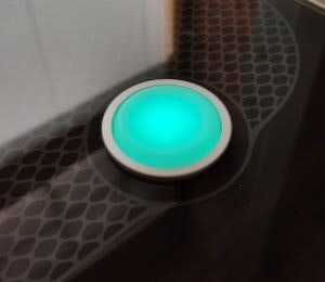 The button on the top of the Glowforge. It is glowing teal.