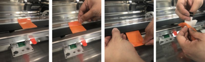 Image sequence of two hands carefully removing tape from the laser arm