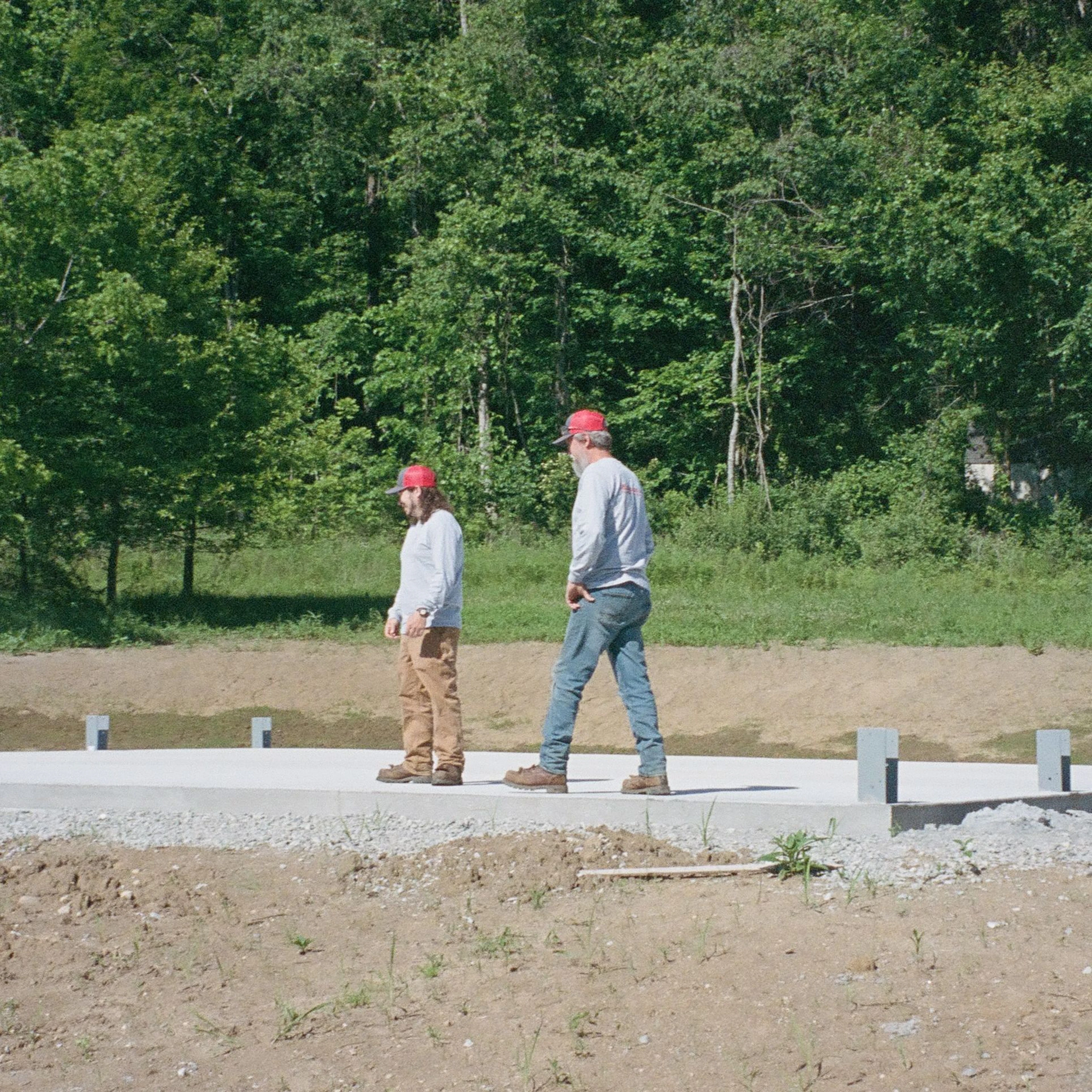 Two crew members on the concrete pad at the 22 Maple Ave site