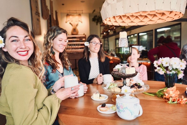 Three women and one girl enjoying afternoon tea